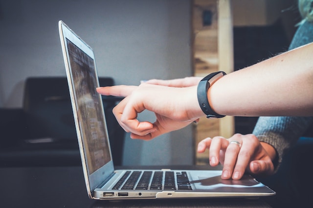 Two people working together on a laptop computer